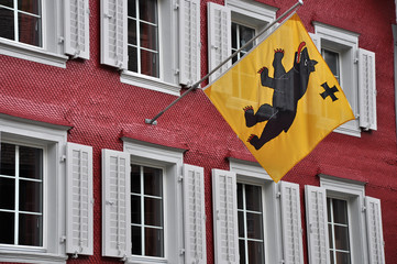 andermatt, edificio storico a scandole con bandiera