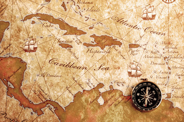 An old brass compass on a Treasure map background