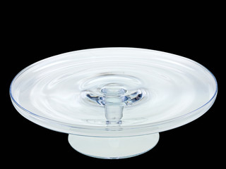 glass cake platter with pedestal on black background