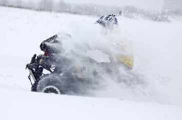 The quad bike's driver rides over snow track