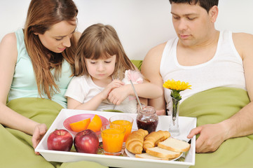 happy young family eat breakfast in bed