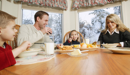 Family Smiles At Breakfast Table