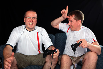 Two football supporters playing soccer on games console