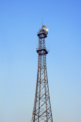 Communication tower over a deep blue sky.