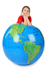 boy in red shirt leans on inflatable globe chin on hands