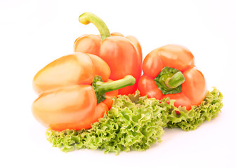 three orange sweet  peppers and salad over white