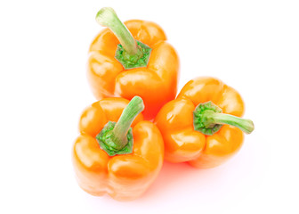 three orange peppers over white