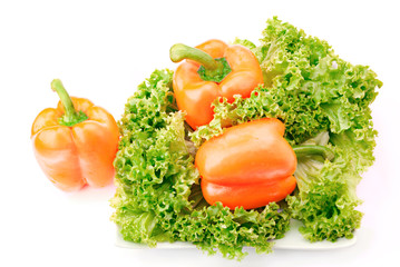 three orange sweet  peppers and salad over white
