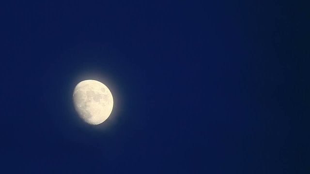 Half moon moving across the evening sky