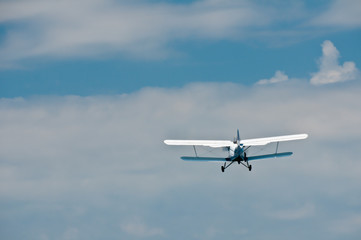 Fototapeta na wymiar Fling away small blue-white plane