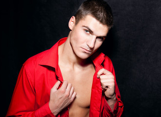 Beautiful young modern macho man in red shirt  is posing