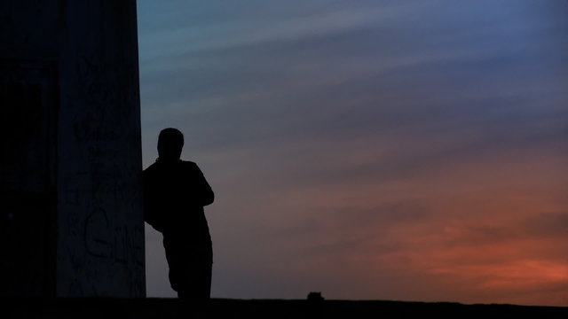 Thoughtful man standing towards sunset/sunrise. HD 1080p.