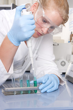 Chemikerin mit Pipette in einem Reagenzglas
