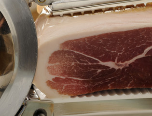 Prosciutto crudo su affettatrice