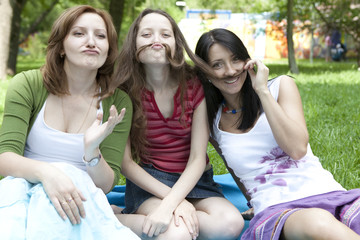 Three friends sitting at tree have a fun.