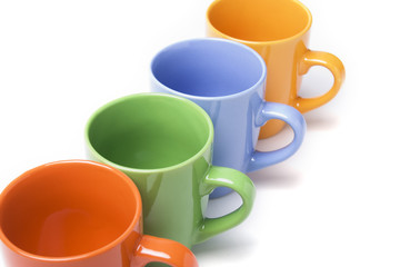 Coffee mugs line with different colors over white
