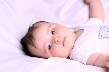 Little thoughtful girl lying on her back