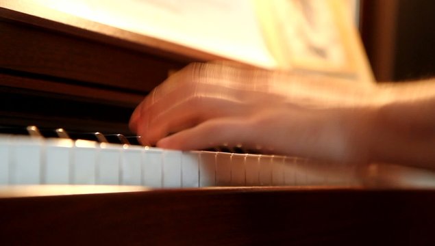 Men hands playing the piano with shallow depth of field