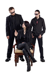 Two men in black clothes stay behind sitting on chair woman