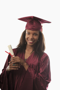female college graduate in cap and gown with diploma