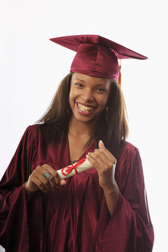 female college graduate in cap and gown with diploma