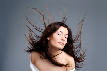 Portrait of a beautiful young woman with hair flying