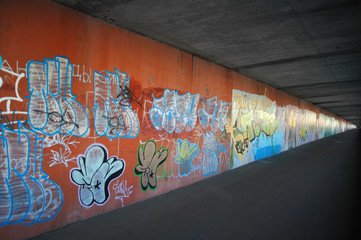 Concrete underground with colorful graffiti wall.