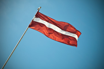 Latvian national flag waving in the sky.