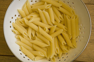 Pasta in colander on table