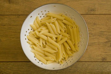 Pasta in colander on table