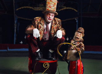 Circus clown with a monkey.