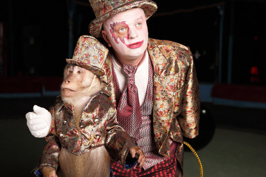 Circus clown with a monkey.