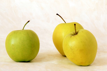 Three yellow apples on painted background
