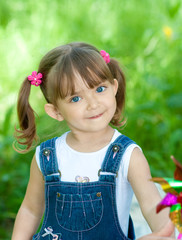 Little girl in jeans with blue eyes outdoor