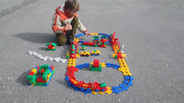boy plays plastic railway