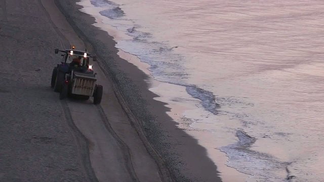 TRACTORISTA LIMPIANDO LA PLAYA AL AMANECER