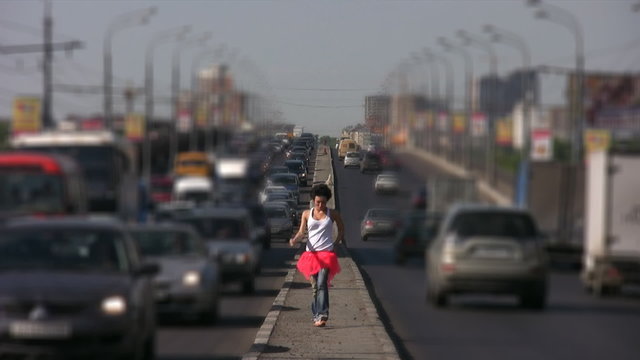 dancing girl walks on highway middle in city