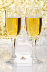 engagement ring with glasses of champagne