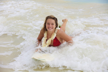 teenage girl in the ocean with her surfboard at kailua beach
