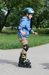 Obraz premium Preschooler learning to ride on rollerblades