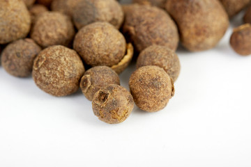 Detail shot of a pile of black peppercorns. All isolated