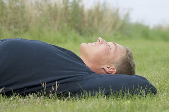 Young man lying in the grass