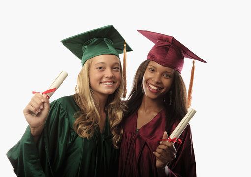 two female graduates in cap and gown with diplomas