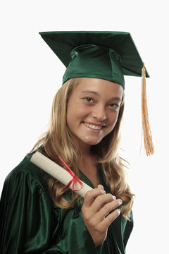 female graduate in cap and gown with diploma.