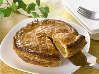 Fresh baked apple pie with a slice cut out isolated.