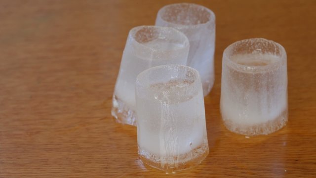 Wine-glasses from ice with vodka thaw on table