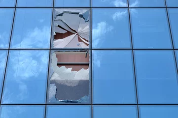 Photo sur Plexiglas construction de la ville Broken glass of an office building window