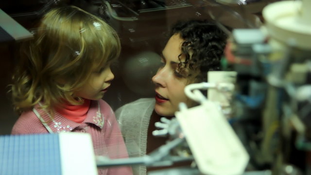 mother telling  girl about space exhibit in space museum