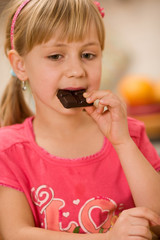 girl eating chocolate - obrazy, fototapety, plakaty