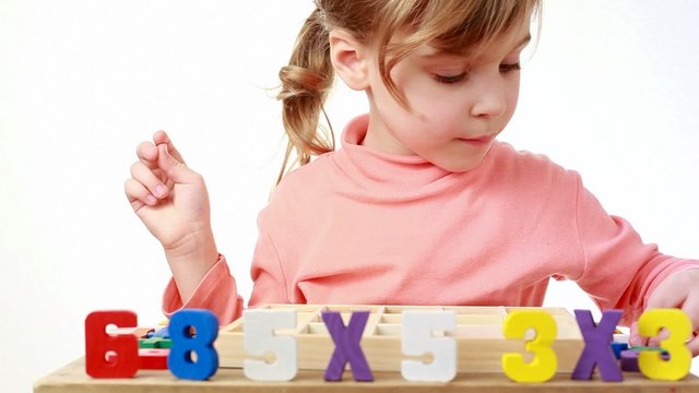 girl pulls out figures of box with cells and puts them on table